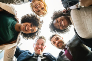 Group of smiling people in circle looking down