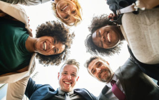 Group of smiling people in circle looking down