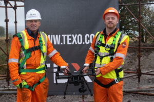 Conal Ferguson holding a drone alongside trainer Ian Cameron from Texo Compliance