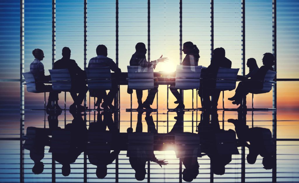 Silhouettes of people at a board meeting