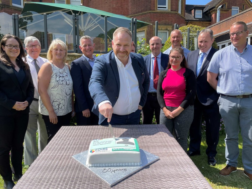Members of the CCNSG committee at the 30th anniversary of the CCNSG with Mark Riley cutting a large birthday cake