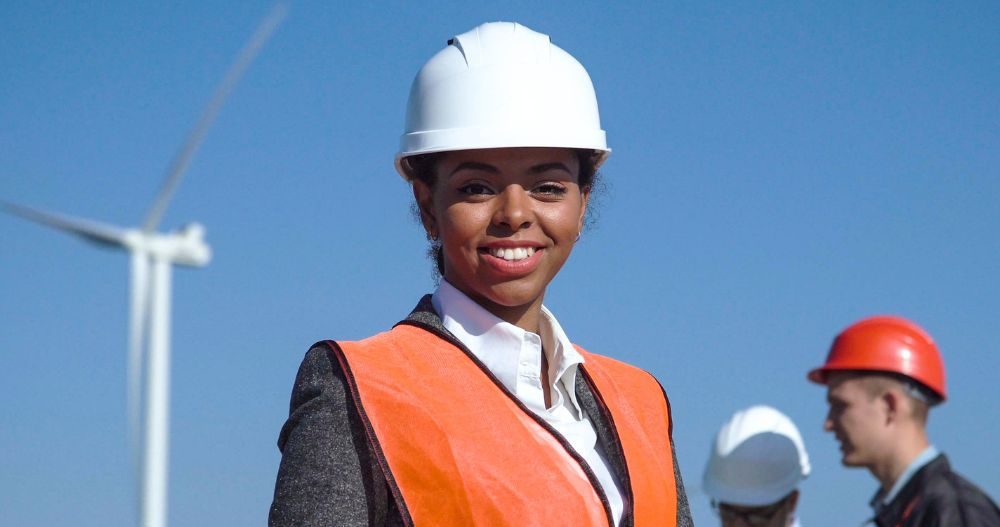 A Woman Holding A Tablet In Front Of Wind Turbines Aspect Ratio 760 400