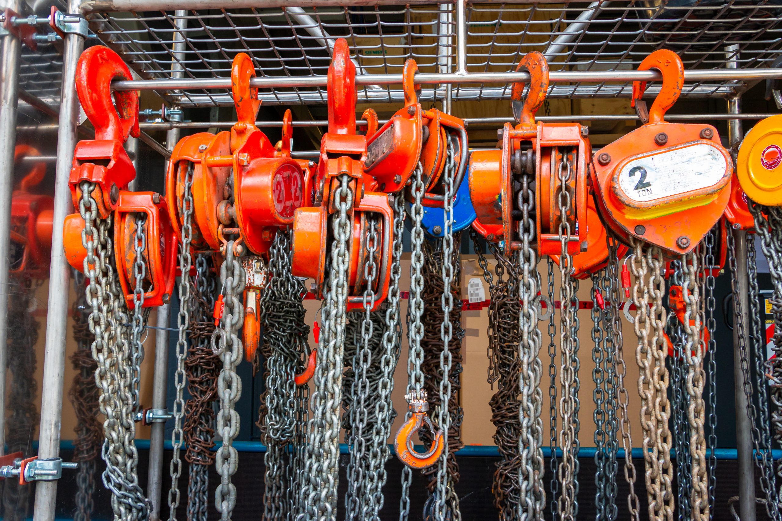 Multiple Chain Hoists Hanging In A Rack Ready For Use In A Industrial Environment, Picture Taken In The Netherlands