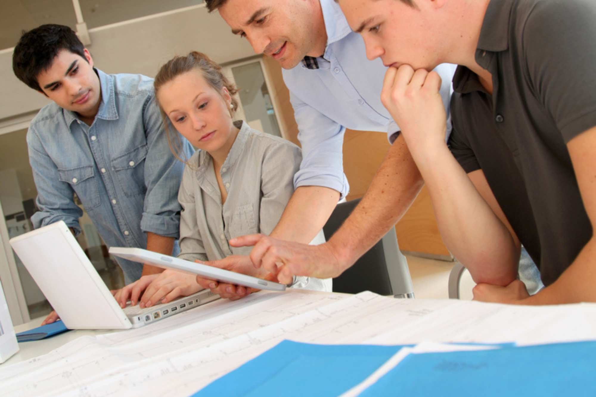 Group Of Learners Looking At Blue Print Plans Aspect Ratio 1200 800