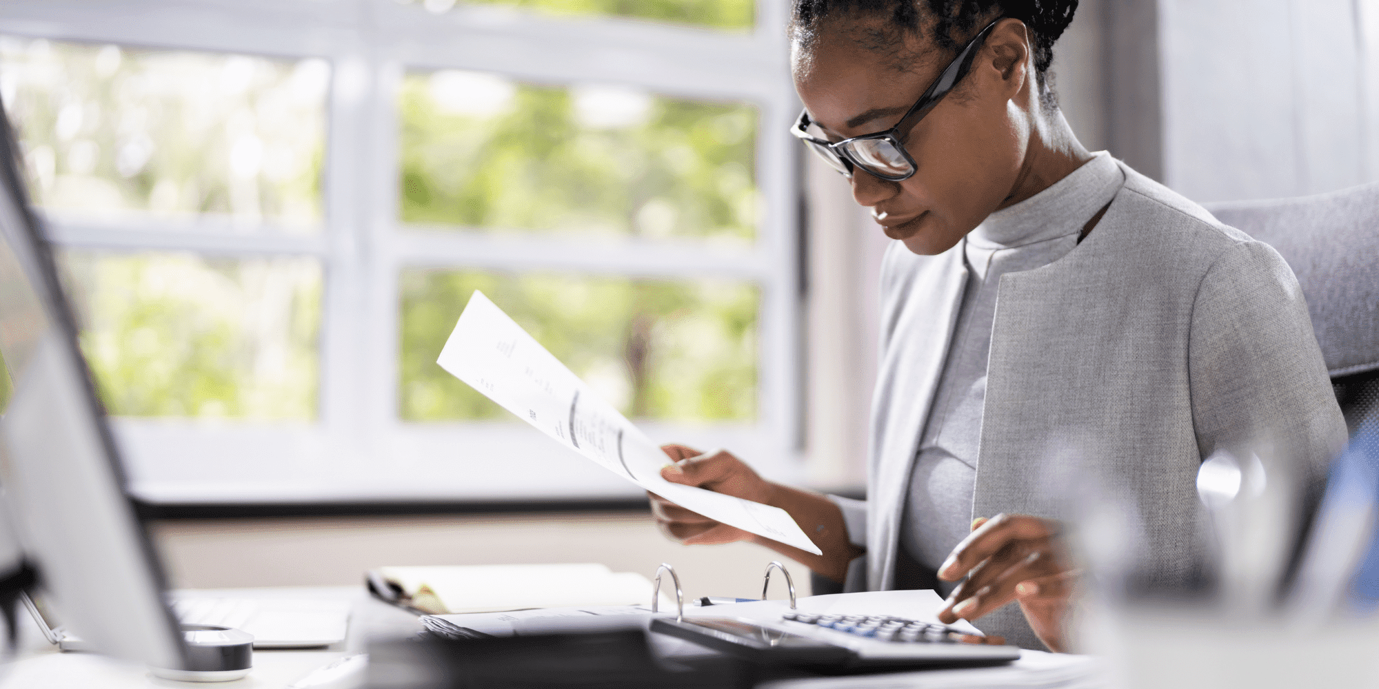 Project Control Lady In Glasses At A Computer With Papers And A Calculator Aspect Ratio 1160 580