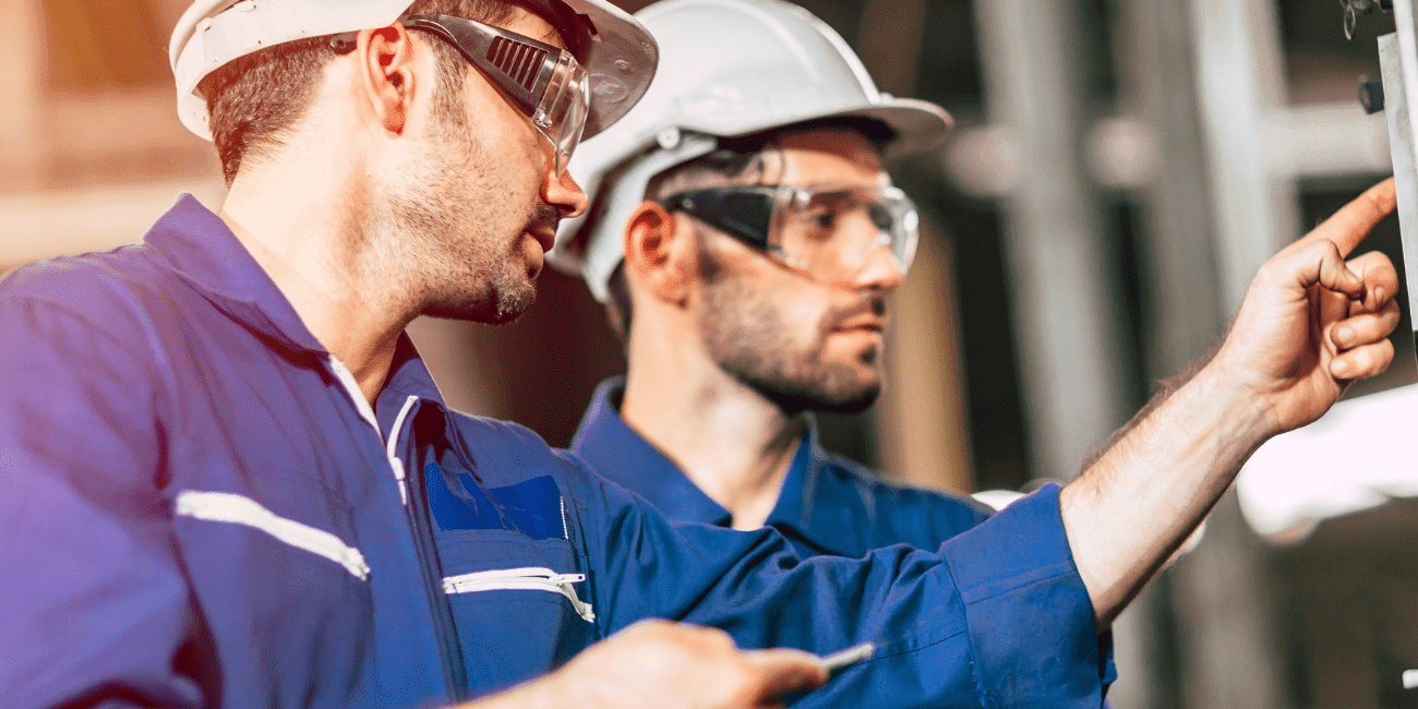 Two Men In PPE Looking Inspecting Equipment  Aspect Ratio 1160 580