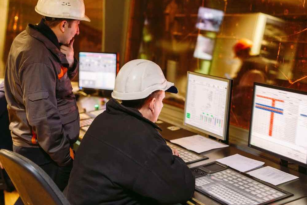 Two Men In White Hard Hats Working At A Controls Panel Aspect Ratio 1200 800