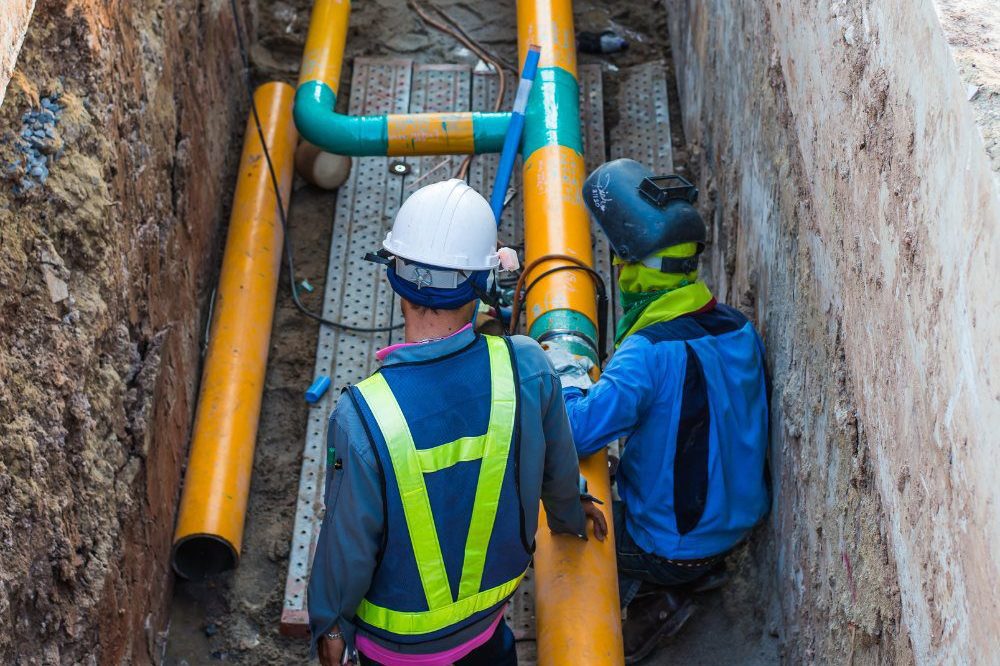 Two People On Site In PPE Pipefitting Outdoors  Aspect Ratio 1200 800