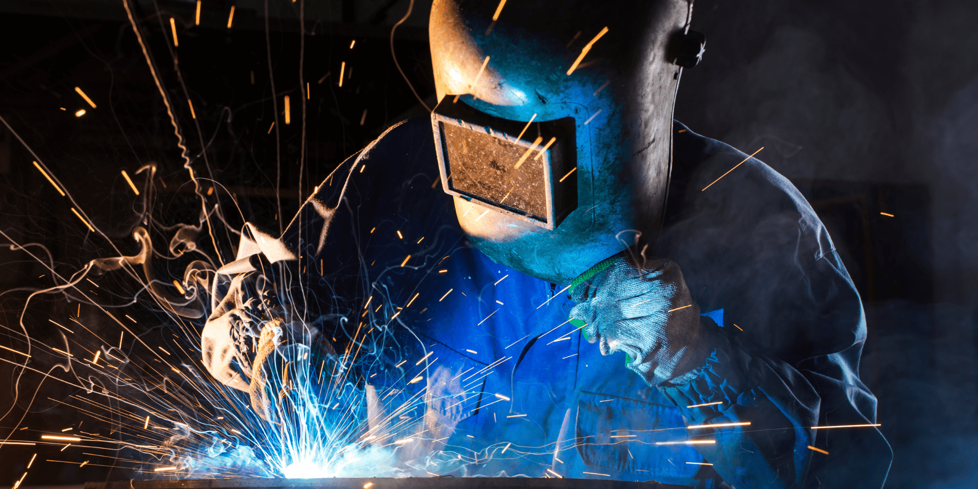 Welding Person In PPE Welding Up Close In A Dark Room Aspect Ratio 1160 580