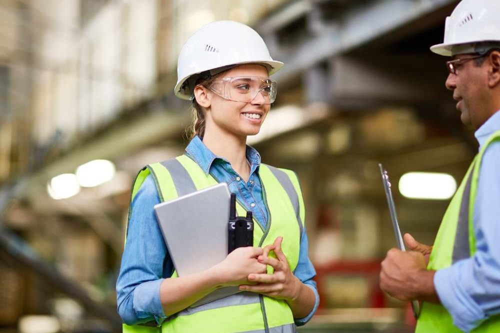 Two People Talking On Site Wearing White Hard Hats
