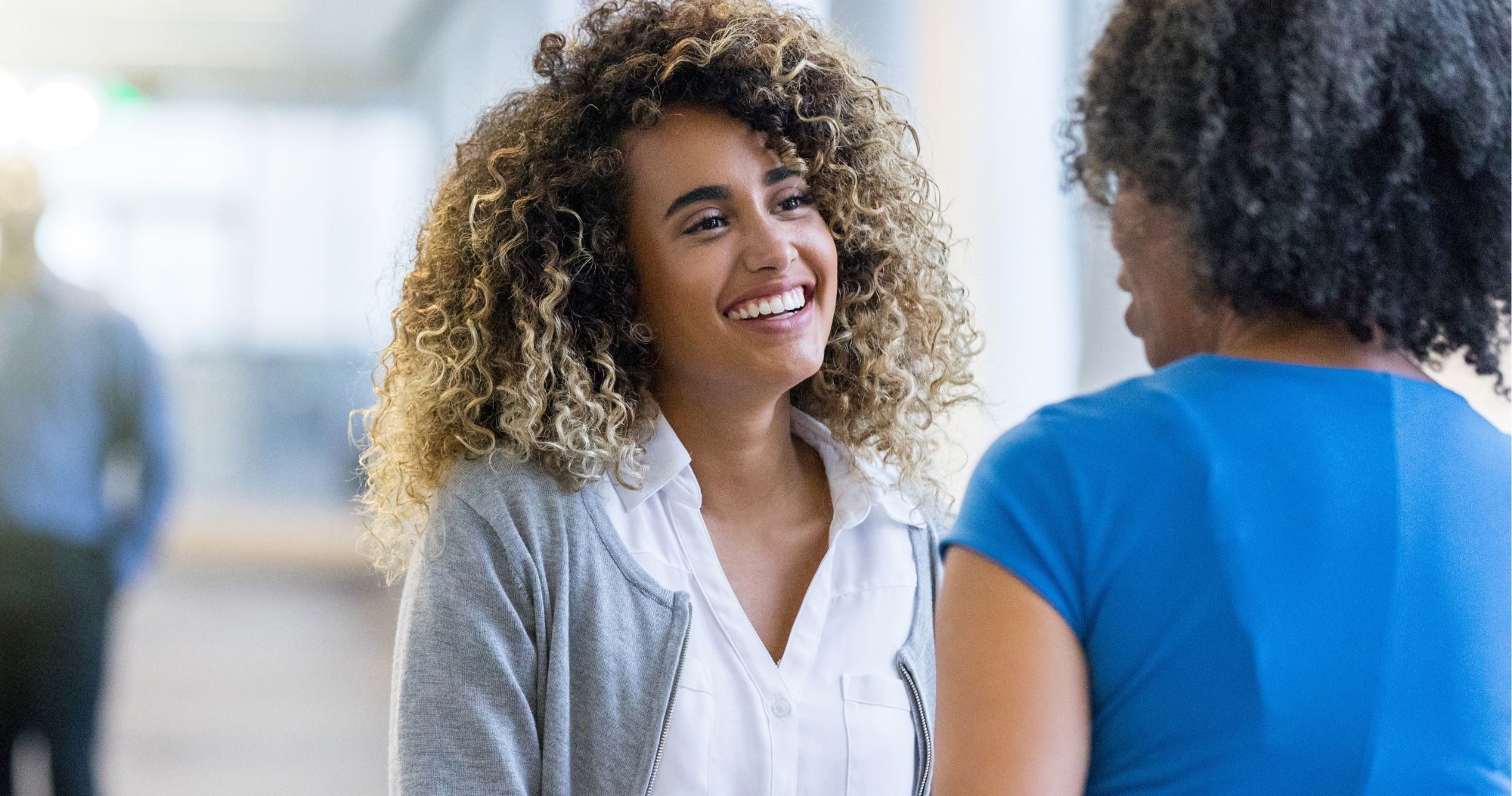 Two Women Shaking Hands In An Office Building
